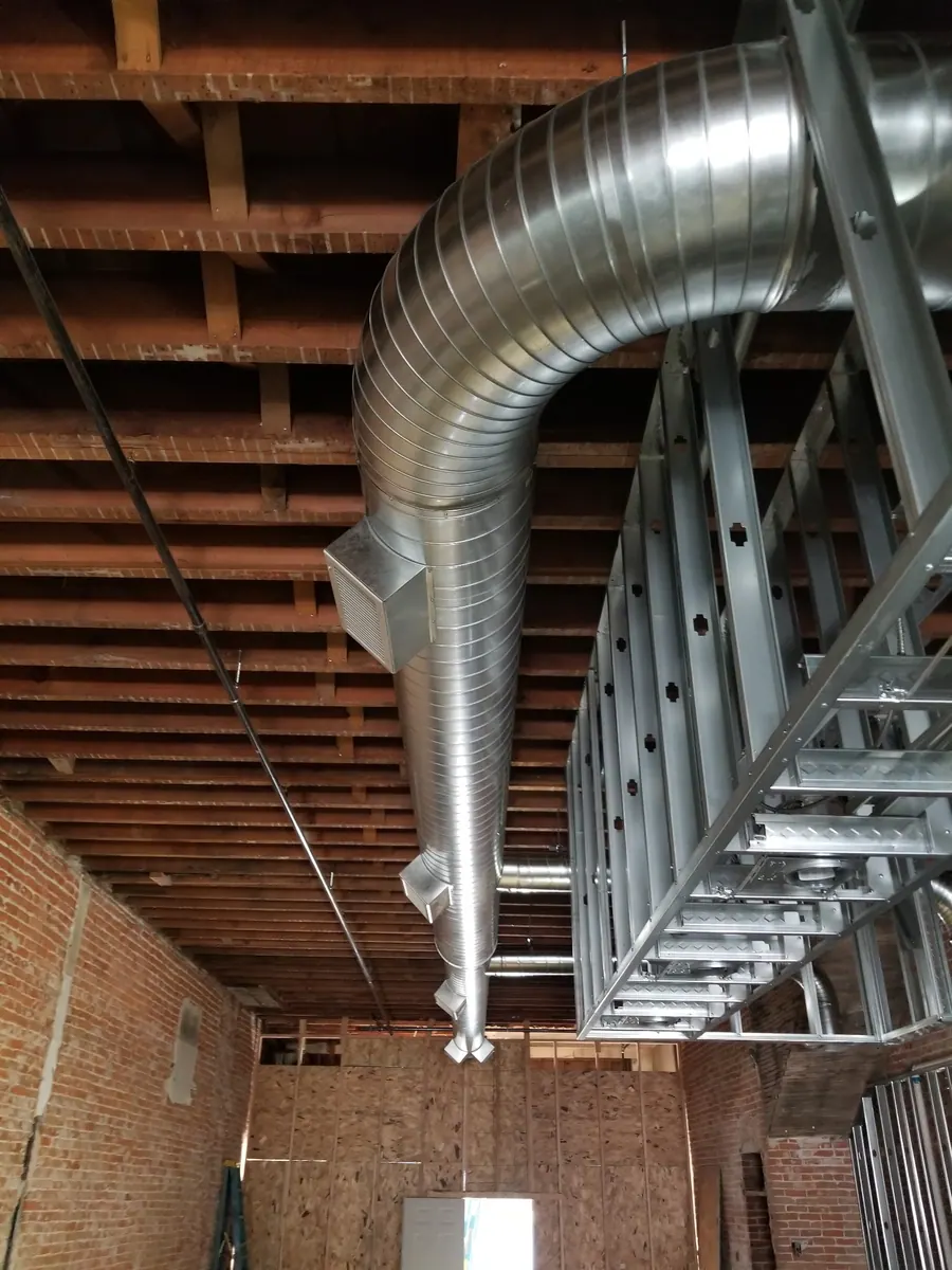 Custom sheet metal ductwork installed between framing